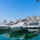 Image of the harbor area in Marbella, Spain, including some private yachts and a hotel in the background