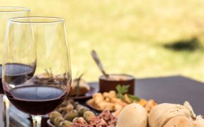 image showing a luxuriously decorated table with two glasses of wine and some delicious food