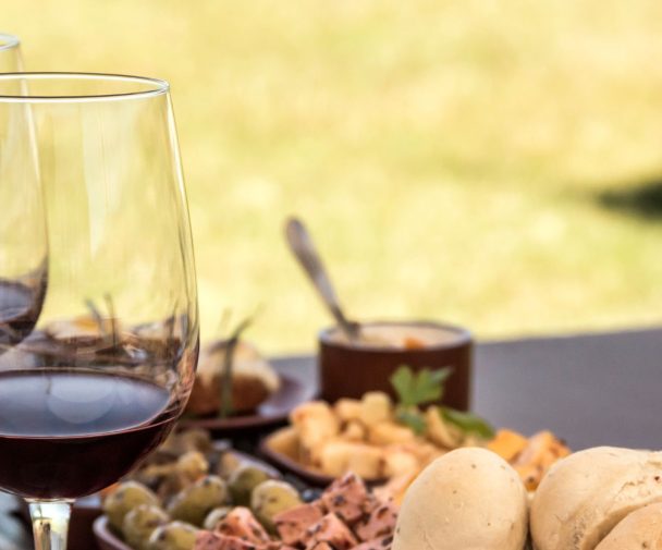 image showing a luxuriously decorated table with two glasses of wine and some delicious food